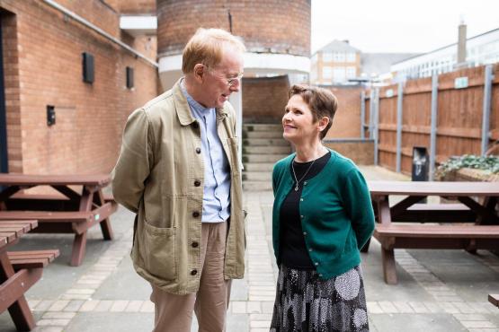 A man and a woman smiling and talking to each other