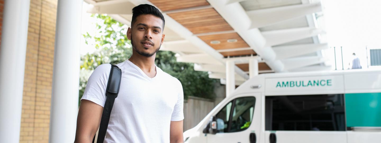 A young black man standing in front of an ambulance