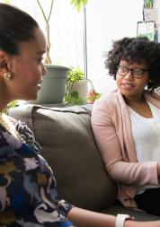 Two women sitting on a sofa and talking