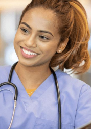 A female health professional in blue scrubs smiling